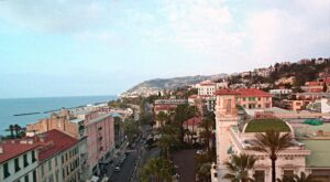 Sanremo streets panoramic view with people and palm trees.