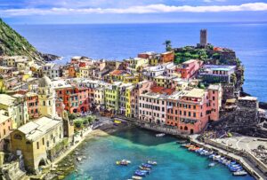 Colorful houses by the sea in Liguria, fishing boats at the pier in Liguria.