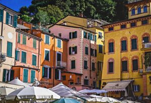 A buildings with a red and white facade and columns in Liguria, Italy.