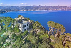 A large house between trees on a cliff with stunning sea view in Italy