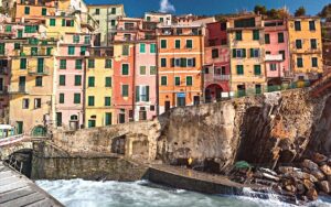 A colorful row of houses with stone bridge over the sea in Liguria, Italy.