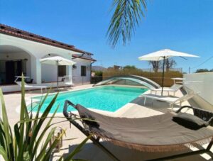 A large house with a terrace and a stunning sea view, pool and palm trees in Italy